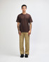 A model wears a brown American Apparel Super Heavyweight T-Shirt paired with olive green cargo pants and sneakers.