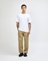 A man wearing a plain white American Apparel Super Heavyweight T-Shirt paired with light blue jeans and black shoes.
