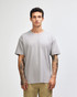 A grey American Apparel Super Heavyweight T-Shirt on a model, featuring a simple design and loose fit.