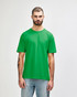 A green Gildan Softstyle adult t-shirt displayed on a model, featuring a plain design and a label.