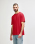 A red Gildan Softstyle adult T-shirt is displayed on a model wearing blue jeans. The shirt features a logo.