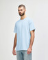 A softstyle adult t-shirt in light blue displayed on a model, featuring a round neck and short sleeves. It has a logo.