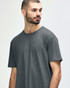 A model wearing a Gildan Softstyle adult t-shirt in dark grey with a round neckline and short sleeves.