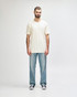 A white Gildan Softstyle adult T-shirt displayed on a model, paired with light blue jeans. The model stands against a neutral background.