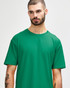 A green adult T-shirt displayed on a model, featuring short sleeves and a relaxed fit. It has a logo on it.