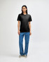 A black American Apparel Tri-Blend T-Shirt displayed on a model paired with light blue jeans. The shirt has a small logo.