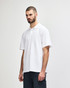 A model wearing a plain white double pique polo shirt, featuring a subtle logo on the chest.