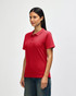 A red Gildan Softstyle Ladies' Double Pique Polo is displayed on a model, featuring a collar and short sleeves.