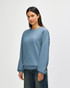 A soft blue sweatshirt with a crew neckline and long sleeves, featuring a logo on the chest.