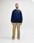 A navy blue Gildan Softstyle adult sweatshirt, shown on a model paired with black pants and sneakers.