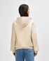 A beige hooded sweatshirt with a back view and a hood, featuring long sleeves and a simple design.