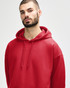 A red hooded sweatshirt is worn by a woman, featuring a drawstring hood and a relaxed fit.