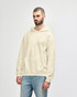 A light beige hooded sweatshirt on a man, featuring a front pouch pocket and a casual fit.