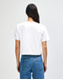 A white women's boxy t-shirt from American Apparel, featuring a plain back, paired with denim jeans.