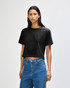 A black women's fine jersey boxy T-shirt displayed on a model, featuring a simple design and relaxed fit.
