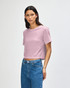 A pink women's boxy t-shirt with a relaxed fit, featuring a logo, styled with denim jeans.
