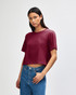A maroon women's fine jersey boxy t-shirt displayed on a model with curly hair, featuring a casual fit.