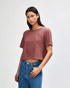 A model wears a dusty rose American Apparel women's fine jersey boxy T-shirt, featuring a relaxed fit and short sleeves.