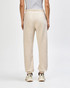 Unisex sweatpants in a beige colour with an elasticised waistband and cuffs, featuring a visible logo.