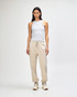 Unisex sweatpants in cream, paired with a pink sweatshirt, worn by a model standing in a neutral background.