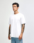 A white unisex short sleeve T-shirt displayed on a model with tattoos, featuring a simple design and relaxed fit.