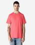 A man in a bright pink Gildan Light Cotton T-Shirt stands against a plain background. The shirt has a logo.
