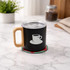 A drink bottle with a black stainless steel body, wooden handle, clear lid, and a coffee cup logo sits on a marble surface.