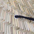 A close-up of a straw hat showcasing the woven texture and a black string threaded through a metal grommet.