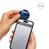 A hand holds a blue NFC acrylic fridge magnet near a smartphone, which displays a notification.
