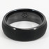 A black carbon fibre ring with a smooth finish and an engraved design on the interior.