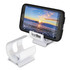 A white phone stand is displayed, supporting a smartphone with a scenic sunset background on the screen.