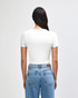 A white women's crop fitted t-shirt with a short sleeve design, displayed from the back, paired with blue jeans.