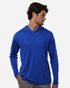 A blue men's performance polo shirt with a hood, featuring long sleeves and a fitted design. It's paired with grey pants.