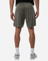 View of a man wearing olive green shorts, showcasing the back design and fit. The shorts have a logo on the side.