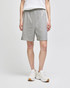 Grey cotton gym shorts with an elastic waistband, worn by a person standing in white shoes. Features a logo.