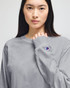 A grey Champion adult long-sleeve t-shirt featuring a small logo on the sleeve.