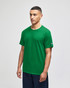 A green Champion adult jersey short sleeve t-shirt displayed on a model, featuring a logo on the sleeve.