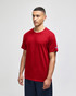 A red Champion adult jersey short sleeve T-shirt displayed on a model, featuring a logo on the sleeve.
