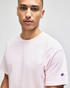A pink Champion Adult Jersey Short Sleeve T-Shirt featuring a logo on the sleeve.