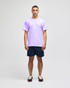 A purple short sleeve t-shirt on a model, paired with navy shorts, featuring a brand logo.