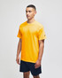 A yellow short sleeve t-shirt with a logo, worn by a model, paired with navy shorts.