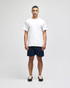 A plain white short sleeve t-shirt with a logo, worn with navy blue shorts.