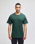 A green Champion adult jersey short sleeve T-shirt displayed on a model, featuring a logo on the sleeve.