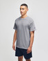 A grey short sleeve t-shirt with a logo, worn by a model, paired with navy shorts.