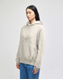 A light grey pullover hooded sweatshirt with a front pocket and a logo, worn by a person standing.
