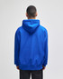 A blue pullover hooded sweatshirt with a large hood, viewed from the back. It features a logo.
