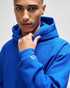 A bright blue Champion Reverse Weave® adult pullover hooded sweatshirt with a logo on the sleeve.