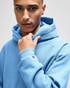 A pullover hooded sweatshirt in light blue, featuring a logo on the sleeve.