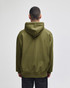 An olive green hooded sweatshirt with a large back pocket and a drawstring hood. The model is facing away from the camera.