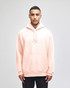 A light pink pullover hooded sweatshirt with a front pocket and a logo on the sleeve.